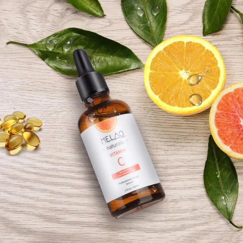 Serum bottle with fresh citrus fruit and gel pearl capsules