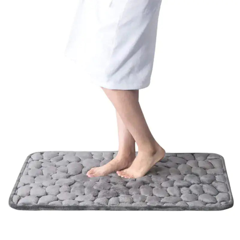 Someone wearing a towel standing on a gray Memory Foam Bath Mat