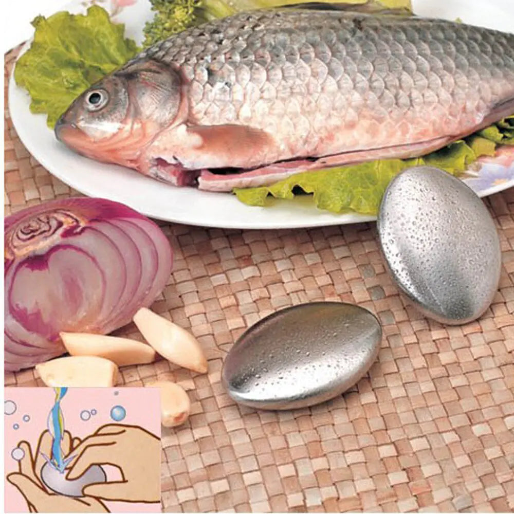 Stainless steel soap leaning on plate with fresh fish and a fresh onion and fresh garlic