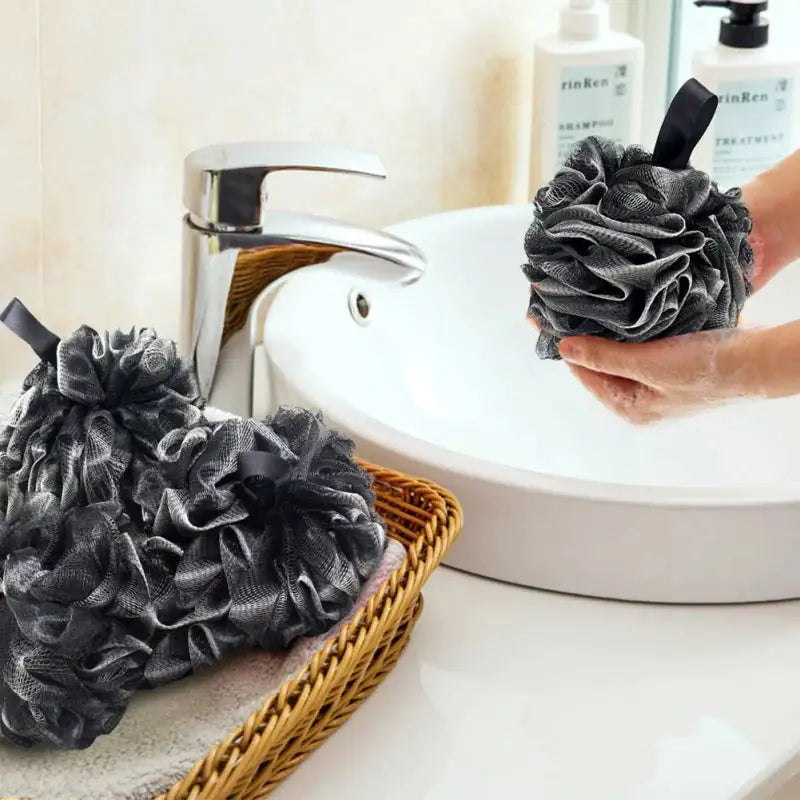 bamboo charcoal bath loofa poof being used at a bathroom sink