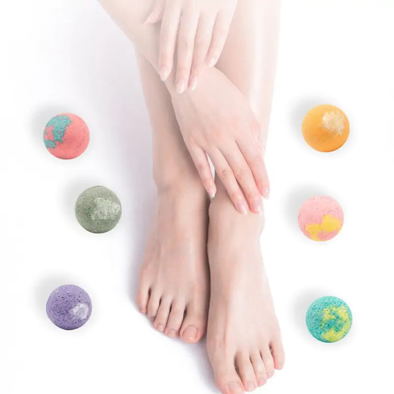 six multi-colored bath bombs around feet and hands