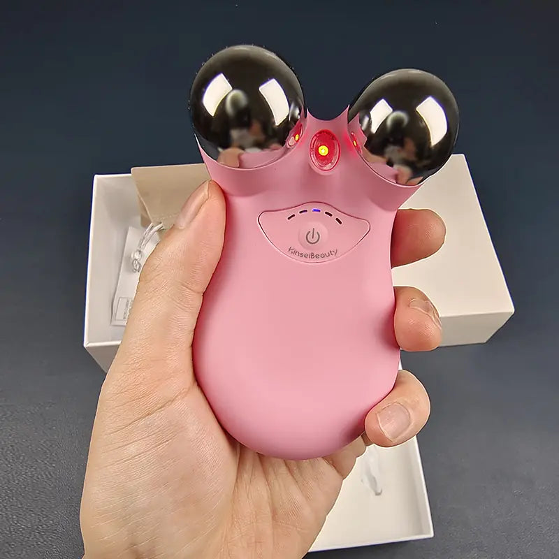 pink Microcurrent Face Massager in a hand with packaging