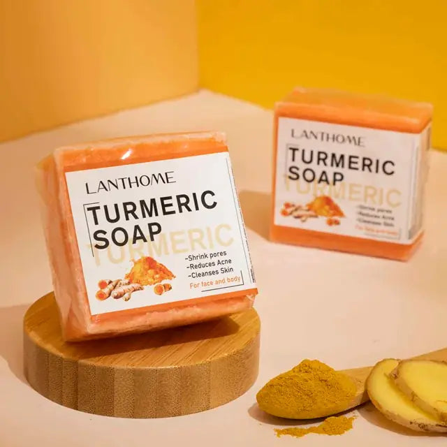 Turmeric Soap in packaging with fresh Turmeric powder on a wooden spoon